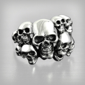 BIKER knit ring for man made of stainless steel carved with multiple death heads on a blackened background.