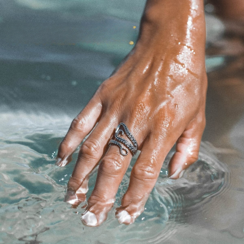 Anillo de pulpo rodado conectado por una mujer para un estilo negrito, marino y afirmó una representación muy realista